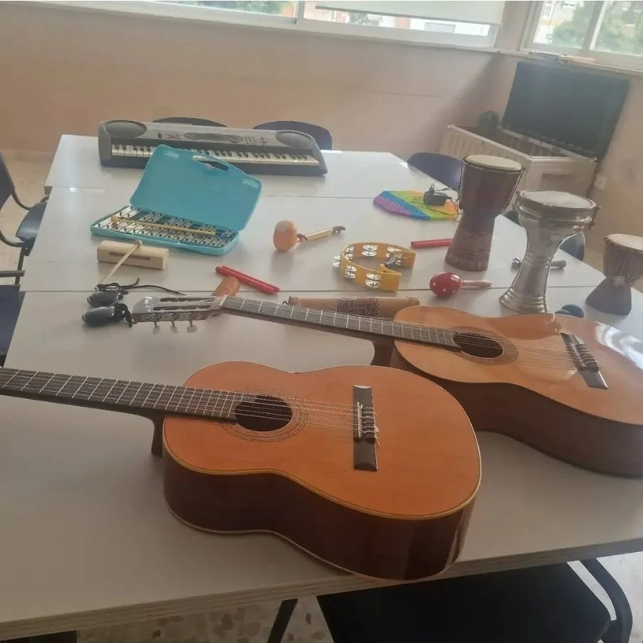 Instrumentos de musicoterapia, guitarras y pequeña percusión sobre una mesa